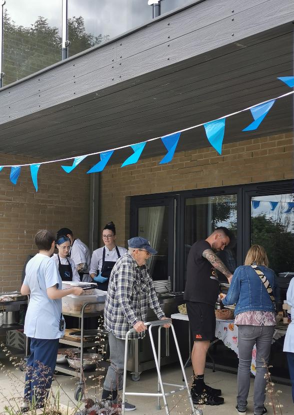 residents and family members enjoying a barbecue with hot dogs