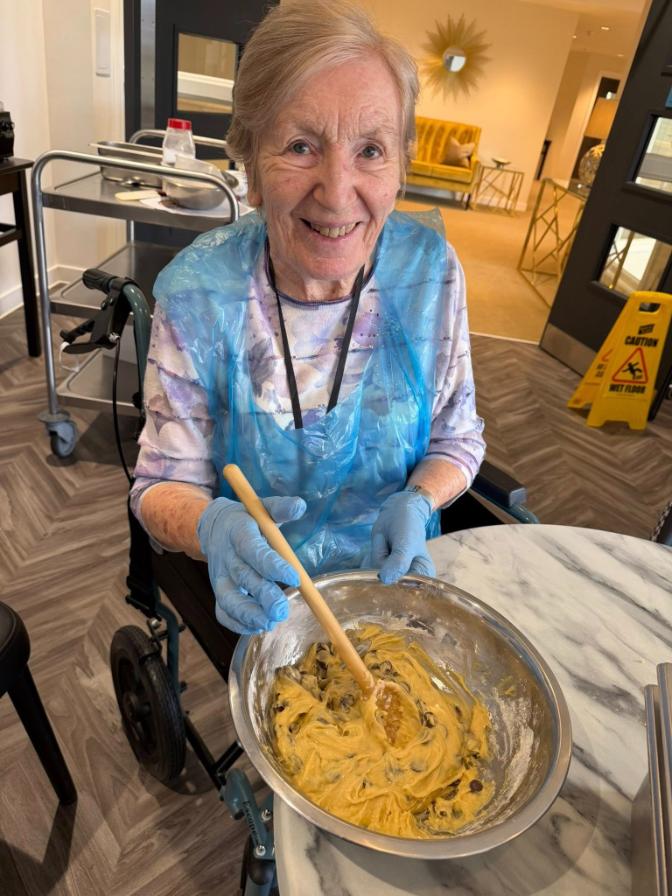 resident baking and smiling at care home