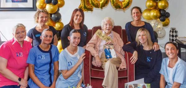 iris celebrating 100th birthday with staff