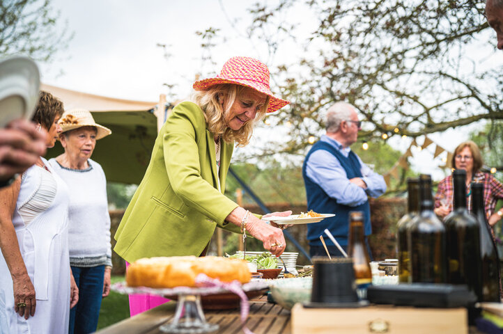 older woman socialising and getting food at a family bbq